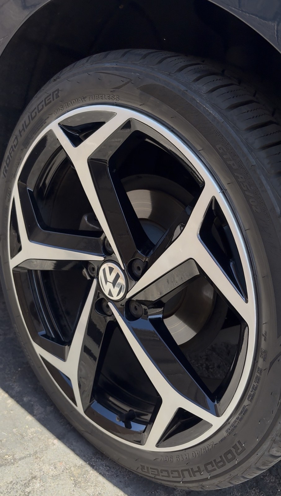 VW wheel after repair — machined face and gloss black restored to factory finish